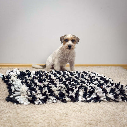 Dog sitting next to the Hea Hoog sniffing mat, designed for mental stimulation and social responsibility.